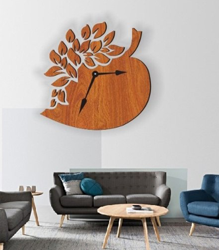Wooden leaf-shaped wall clock with intricate cut-out design on a white living room wall